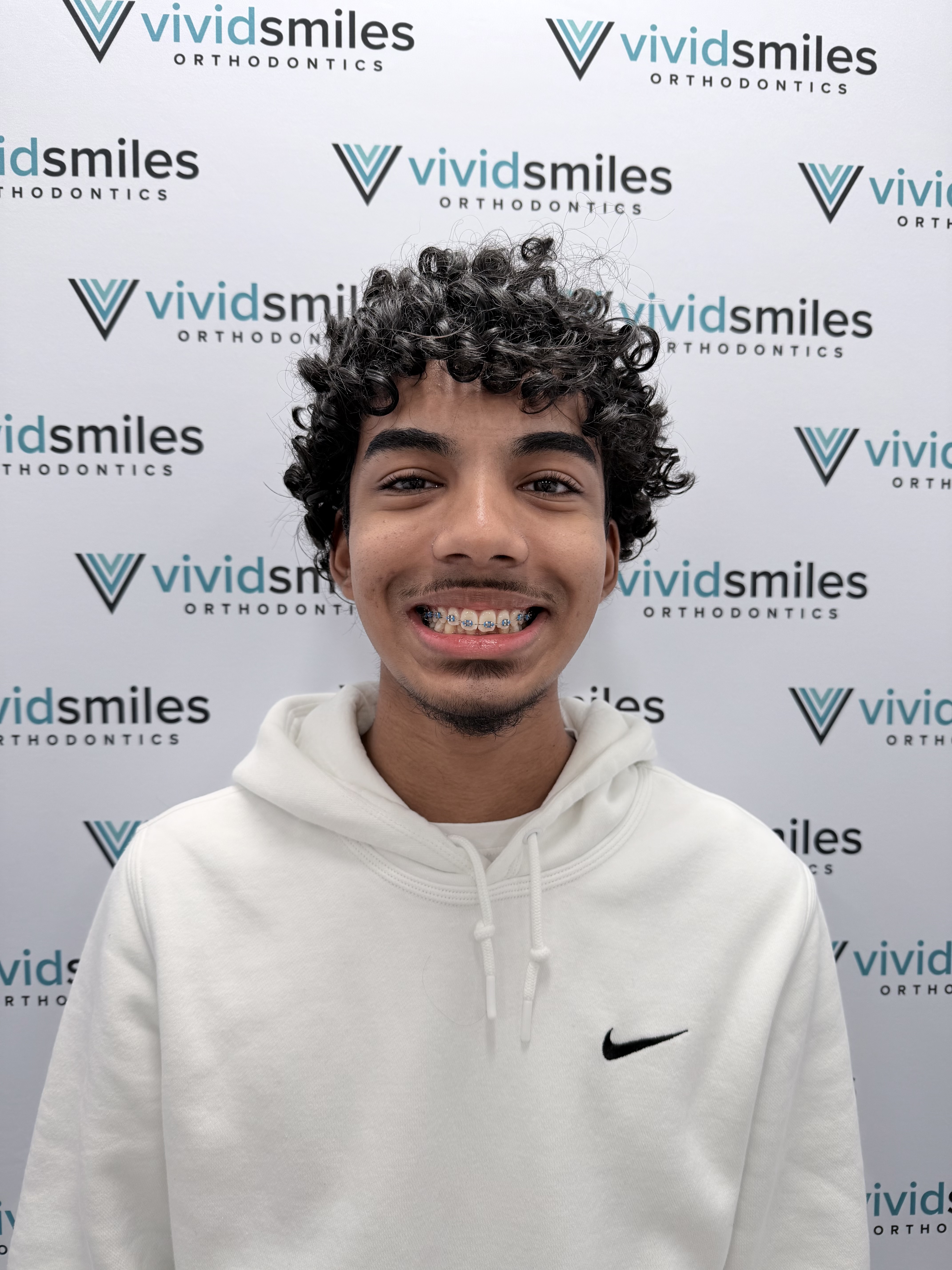 Teenage boy smiling confidently with metal dental braces showing straight aligned teeth