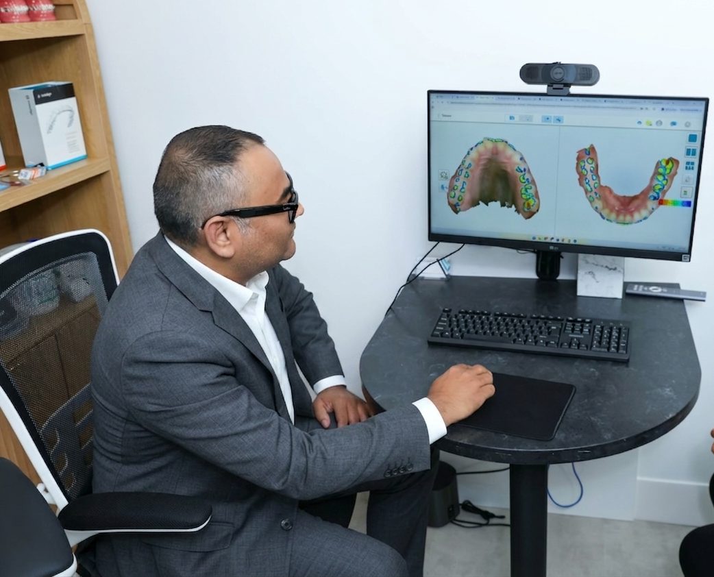 Dr. Singh reviewing digital 3D dental scans on screen during Invisalign treatment planning