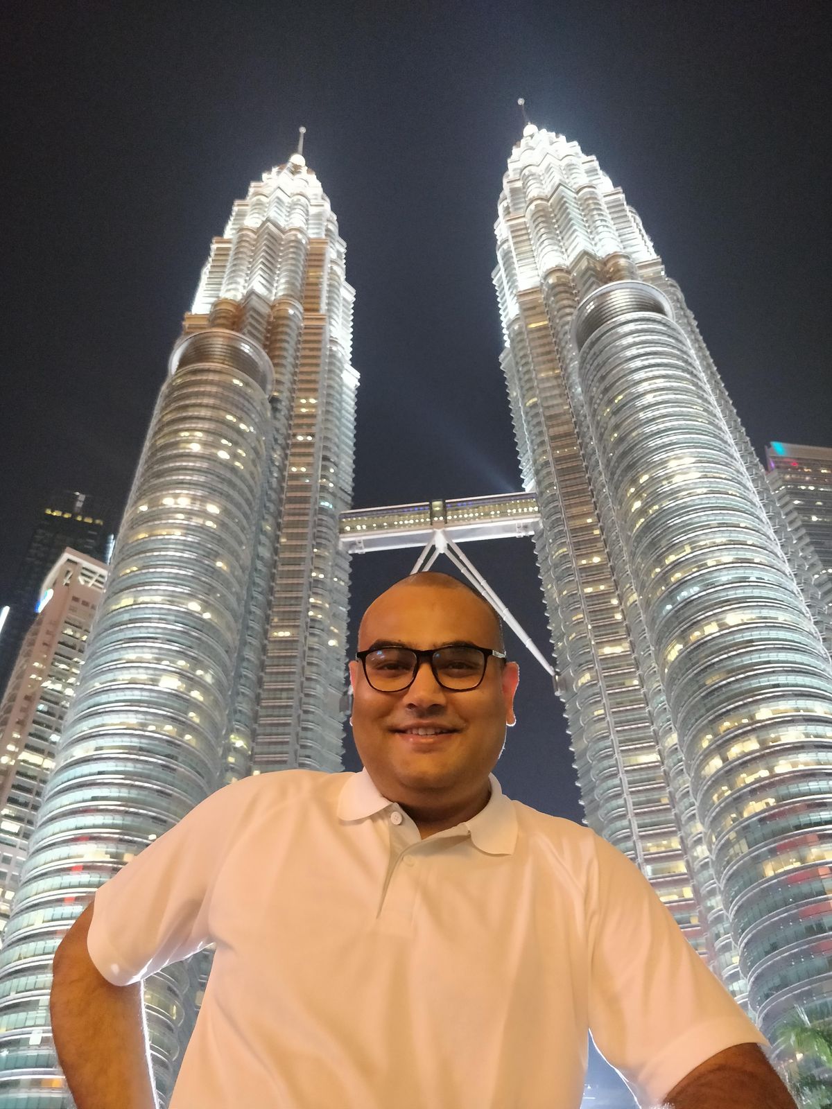 Dr. Singh at the Petronas Towers in Kuala Lumpur at night